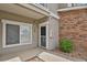 Front door entrance featuring brick accents, pea gravel landscaping, and manicured bushes at 1801 S Dunkirk St # 108, Aurora, CO 80017