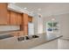 Bright kitchen showcases wood cabinetry, a white refrigerator, and a view to the outdoors through a window at 1801 S Dunkirk St # 108, Aurora, CO 80017