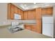 Well-lit kitchen features wood cabinets, white appliances, and neutral countertops for a clean and functional space at 1801 S Dunkirk St # 108, Aurora, CO 80017