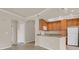 Kitchen featuring wood cabinetry, modern appliances, breakfast bar and hardwood floors at 1801 S Dunkirk St # 108, Aurora, CO 80017