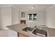 Living space featuring an island counter, stainless steel sink and a cozy fireplace under an arched alcove at 1801 S Dunkirk St # 108, Aurora, CO 80017