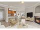 Open concept living room with kitchen, dining area, fireplace, light wood floors and ample natural light at 1801 S Dunkirk St # 108, Aurora, CO 80017