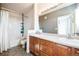 Well-lit bathroom featuring double sinks, wooden cabinetry, and a shower-tub combination at 18726 E Yale Cir # D, Aurora, CO 80013