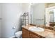 Bathroom with a granite countertop vanity, mirror, and shelving unit for storage at 18726 E Yale Cir # D, Aurora, CO 80013