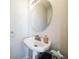 Elegant powder room featuring a pedestal sink, stylish fixtures, and a decorative mirror at 18726 E Yale Cir # D, Aurora, CO 80013