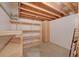 Unfinished basement with open ceiling, storage shelves, and cabinet, offering potential for customization at 8545 Braun Loop, Arvada, CO 80005