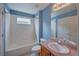 Inviting blue bathroom with white tile tub and vanity with framed mirror at 8545 Braun Loop, Arvada, CO 80005