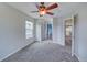 Bedroom with gray carpet, ceiling fan, and access to bathroom and hallway at 8545 Braun Loop, Arvada, CO 80005