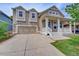 Charming two-story home featuring a covered porch, two-car garage, and manicured lawn at 8545 Braun Loop, Arvada, CO 80005