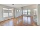 Open-concept living room with hardwood floors, large windows, and modern lighting fixtures at 8545 Braun Loop, Arvada, CO 80005