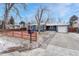 Charming single-story home with a well-maintained lawn, driveway, and red fence at 1660 Reed St, Lakewood, CO 80214