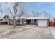 Inviting single-story home featuring blue siding and a well-manicured front yard at 1660 Reed St, Lakewood, CO 80214