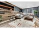 Stylish living room featuring wood accent wall, built-in shelving and gray sectional sofa at 1660 Reed St, Lakewood, CO 80214