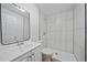 Bright white bathroom with tiled shower, commode, and a sink vanity with a mirror at 16251 E 17Th Pl # C, Aurora, CO 80011