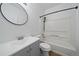 Well-lit bathroom features gray vanity with a round mirror and a shower-tub combination at 16251 E 17Th Pl # C, Aurora, CO 80011