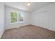 Bright bedroom features a large window, neutral carpet, and plenty of closet space for storage at 16251 E 17Th Pl # C, Aurora, CO 80011