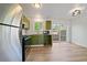 Renovated kitchen with stainless steel appliances and stylish green cabinets leading to outdoor patio at 16251 E 17Th Pl # C, Aurora, CO 80011