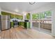 Updated kitchen featuring stainless steel appliances, green cabinetry, and access to outdoor patio at 16251 E 17Th Pl # C, Aurora, CO 80011