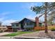 A beautiful home showcases a well-manicured front lawn, mature tree, and an inviting brick chimney at 13588 W Exposition Dr, Lakewood, CO 80228