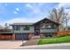 Charming home featuring a two-car garage, unique architectural details, and a well-maintained front yard at 13588 W Exposition Dr, Lakewood, CO 80228