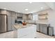 Modern kitchen features gray cabinets, stainless steel appliances, and a center island at 13588 W Exposition Dr, Lakewood, CO 80228