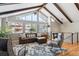 Comfortable living area featuring hardwood floors, exposed beams, vaulted ceiling, and ample natural light at 13588 W Exposition Dr, Lakewood, CO 80228