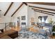 Open floor plan living area with hardwood floors, exposed beams, dining area, and modern decor at 13588 W Exposition Dr, Lakewood, CO 80228