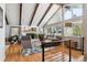 Bright living room with vaulted ceilings, exposed beams, fireplace, hardwood floors, and large windows at 13588 W Exposition Dr, Lakewood, CO 80228