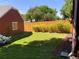 Lush green backyard featuring a privacy fence, well-manicured lawn, and mature trees at 1273 S Jackson St, Denver, CO 80210