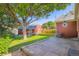 Lush backyard with mature tree, brick patio, detached garage, and well-maintained lawn at 1273 S Jackson St, Denver, CO 80210