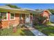 Up close view of the charming brick home with landscaped yard and a walkway leading to the front door at 1273 S Jackson St, Denver, CO 80210