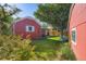 Spacious yard showcasing a red-sided house, green lawn, wooden fence, and charming landscaping at 1273 S Jackson St, Denver, CO 80210