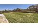 Grassy backyard with partial brick patio, landscaping, and a wood fence line creating a private space at 10808 Salida St, Commerce City, CO 80022