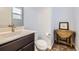 A small half-bath has a modern sink and a vintage side table with a framed photo at 10808 Salida St, Commerce City, CO 80022