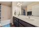 A bathroom featuring double sinks with dark cabinets and a bath tub at 10808 Salida St, Commerce City, CO 80022