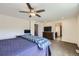 Spacious bedroom with a ceiling fan, dresser with tv, and attached bathroom with barn door at 10808 Salida St, Commerce City, CO 80022