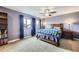 This bedroom features a bed with a quilt, a ceiling fan, and large windows with natural light at 10808 Salida St, Commerce City, CO 80022
