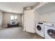 Bedroom featuring a seating area with a gray sofa and a laundry room with a washer and dryer at 10808 Salida St, Commerce City, CO 80022