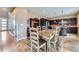 Open-concept dining area with modern table and chairs, with the kitchen in the background at 10808 Salida St, Commerce City, CO 80022