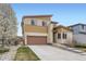 Two-story home with a brown garage door, light-yellow siding, and landscaped front yard at 10808 Salida St, Commerce City, CO 80022