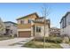 Two-story home with a brown garage door, light-yellow siding, and a landscaped front yard at 10808 Salida St, Commerce City, CO 80022