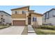 Two-story home with a brown garage door, light-yellow siding, and a well-manicured lawn at 10808 Salida St, Commerce City, CO 80022