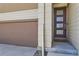Close up of a modern front door, garage door and neutral siding of a charming home at 10808 Salida St, Commerce City, CO 80022