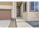 Front entrance featuring a modern front door with glass panels, set of steps, and beige siding at 10808 Salida St, Commerce City, CO 80022
