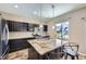 Modern kitchen featuring an island with a granite countertop, stainless steel appliances, and dark cabinetry at 10808 Salida St, Commerce City, CO 80022