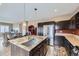 A modern kitchen features an island with a granite countertop, stainless steel appliances, and wooden floors at 10808 Salida St, Commerce City, CO 80022
