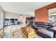 Open-concept living room with wood floors, a leather sofa, and an adjacent home office setup at 10808 Salida St, Commerce City, CO 80022