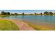 Picturesque community pond with a walking path and lush green surroundings at 10808 Salida St, Commerce City, CO 80022