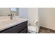Well-lit powder room featuring a modern vanity, white sink, and a tile accent floor at 10808 Salida St, Commerce City, CO 80022