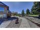 Stone pathway leading to a lush backyard with mature trees and deck at 18045 Sunburst Dr, Monument, CO 80132